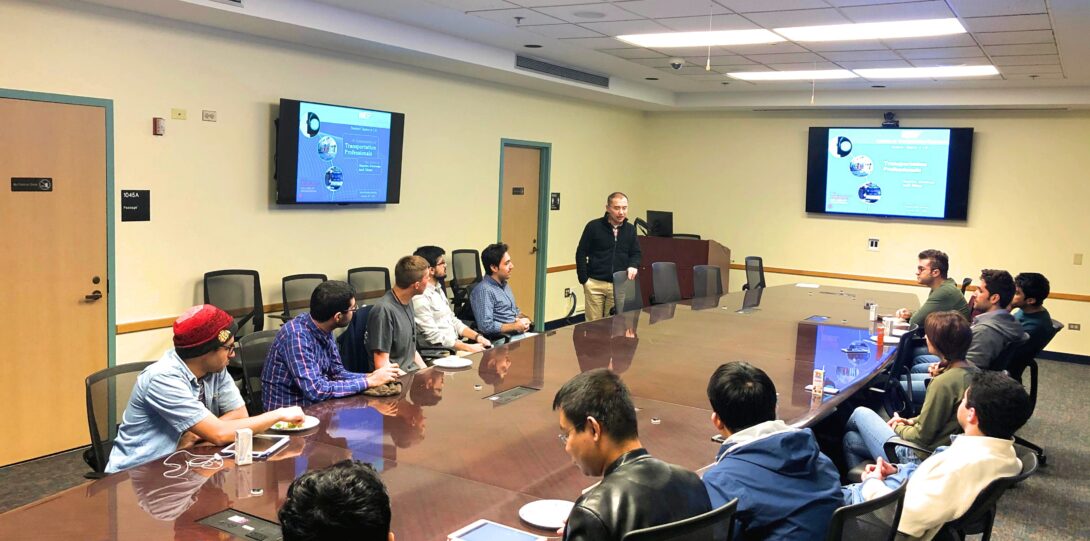ITE GBM 2019 - A large conference room with a long table and a large group of people are seated at the table