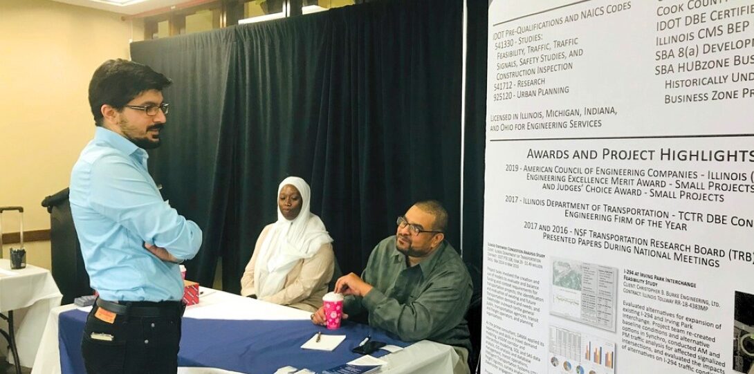 ITE Illinois Student Day 2019 - A man in a light blue shirt speaking with two people seated at a table.