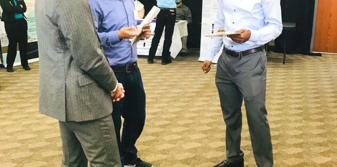 ITE Illinois Student Day 2019 - A photograph of a career fair with three men in the foreground.