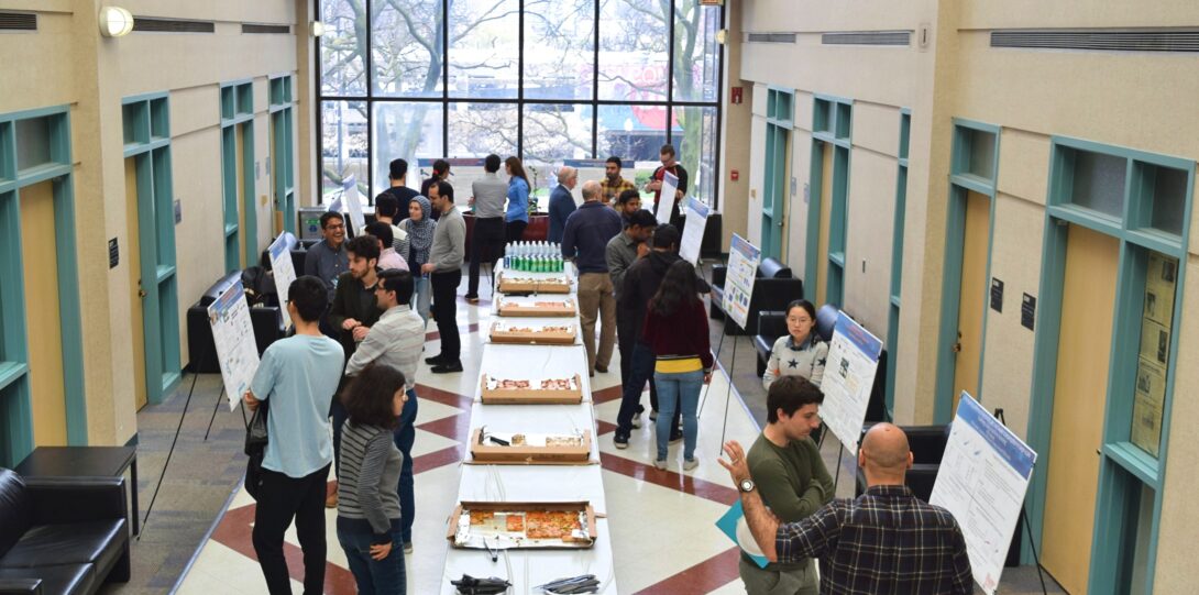 ITE members participating in the CME Poster competition - A long, high-ceilinged hallway is filled with people at a poster session.